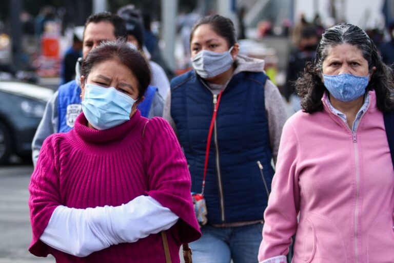 Personas con cubrebocas, chamarras y guantes transitan por el primer cuadro de la ciudad